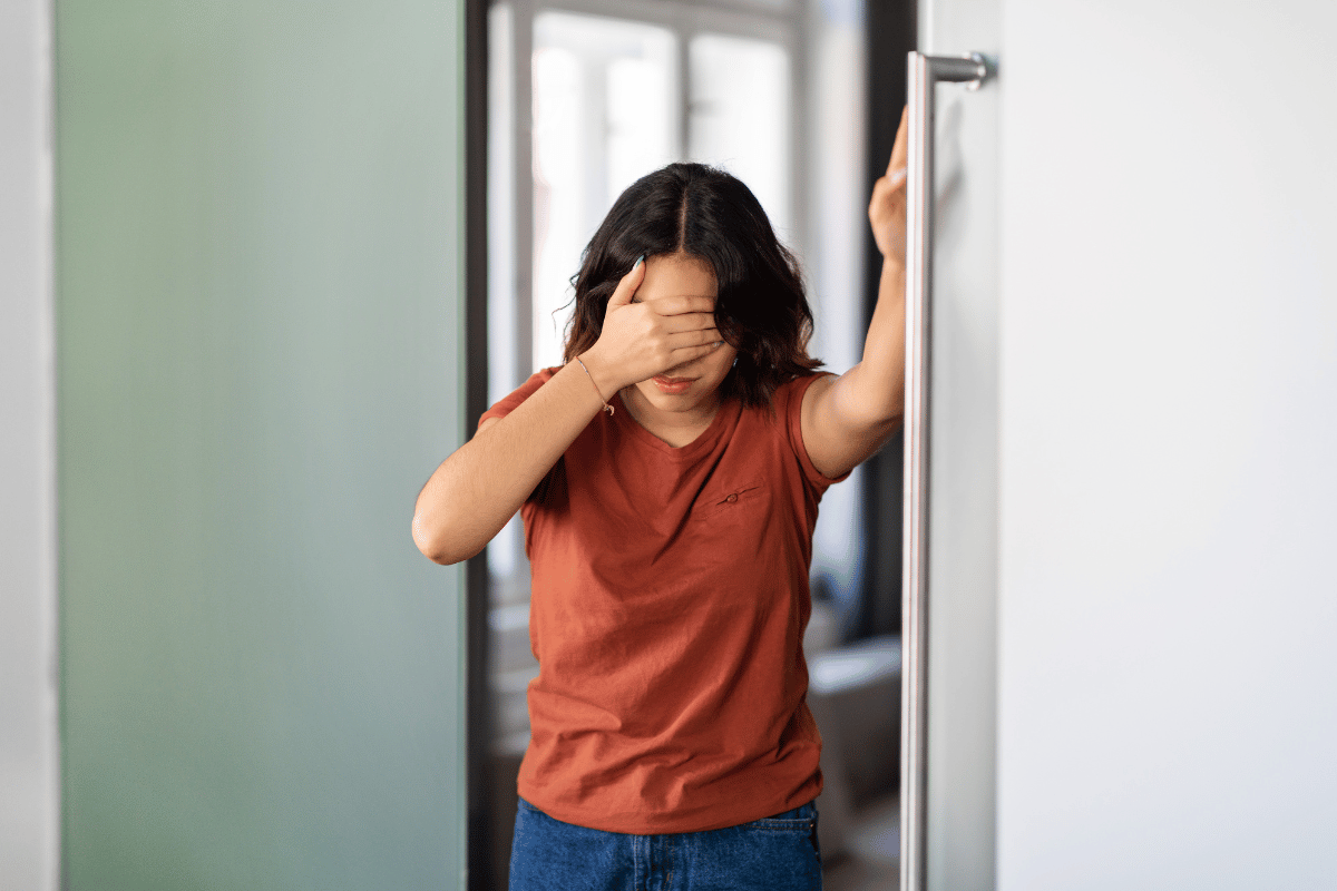 woman feeling dizzy and holding onto the wall