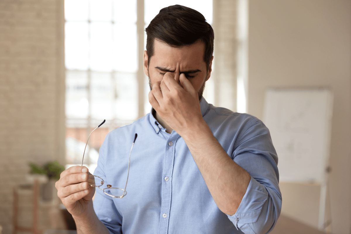 a man looking uncomfortable and holding a hand to his face