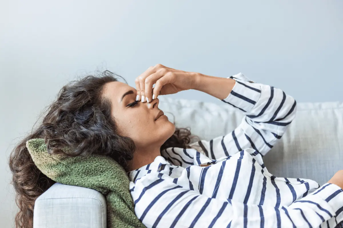 a woman lying on the couch with a headache